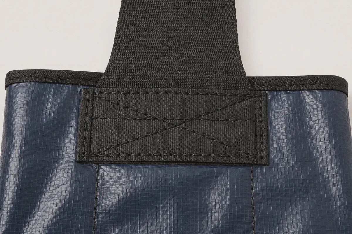 Close view of black polypropylene webbing attached to navy PP woven fabric with reinforced box-X stitching