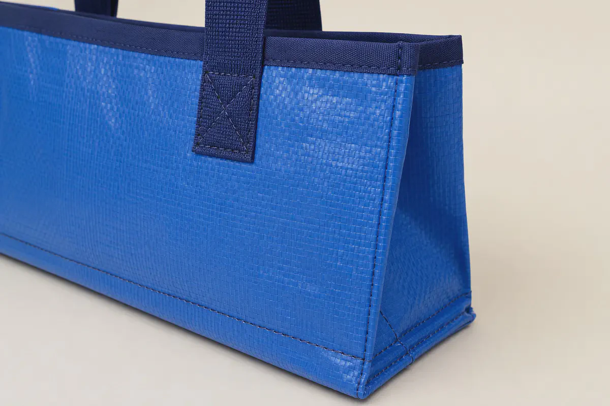 Close-up of reinforced handle stitching, bound edge, side gusset and bottom seam on a PP woven shopping bag