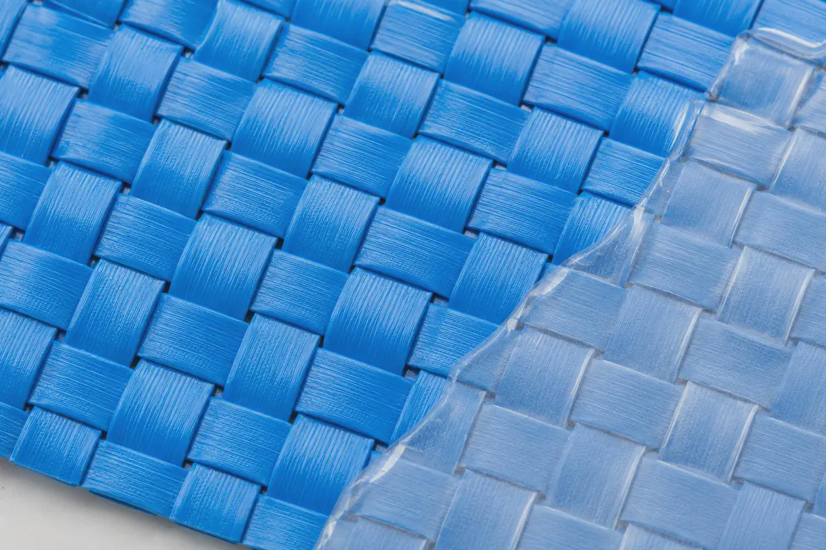 Macro view of polypropylene tapes woven into blue fabric with a clear laminated layer