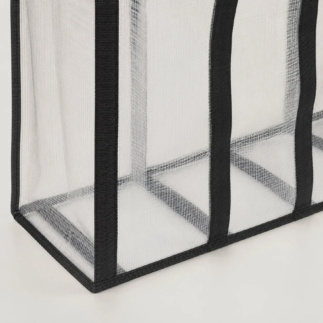 Clear woven bag bottom showing the wraparound webbing load path